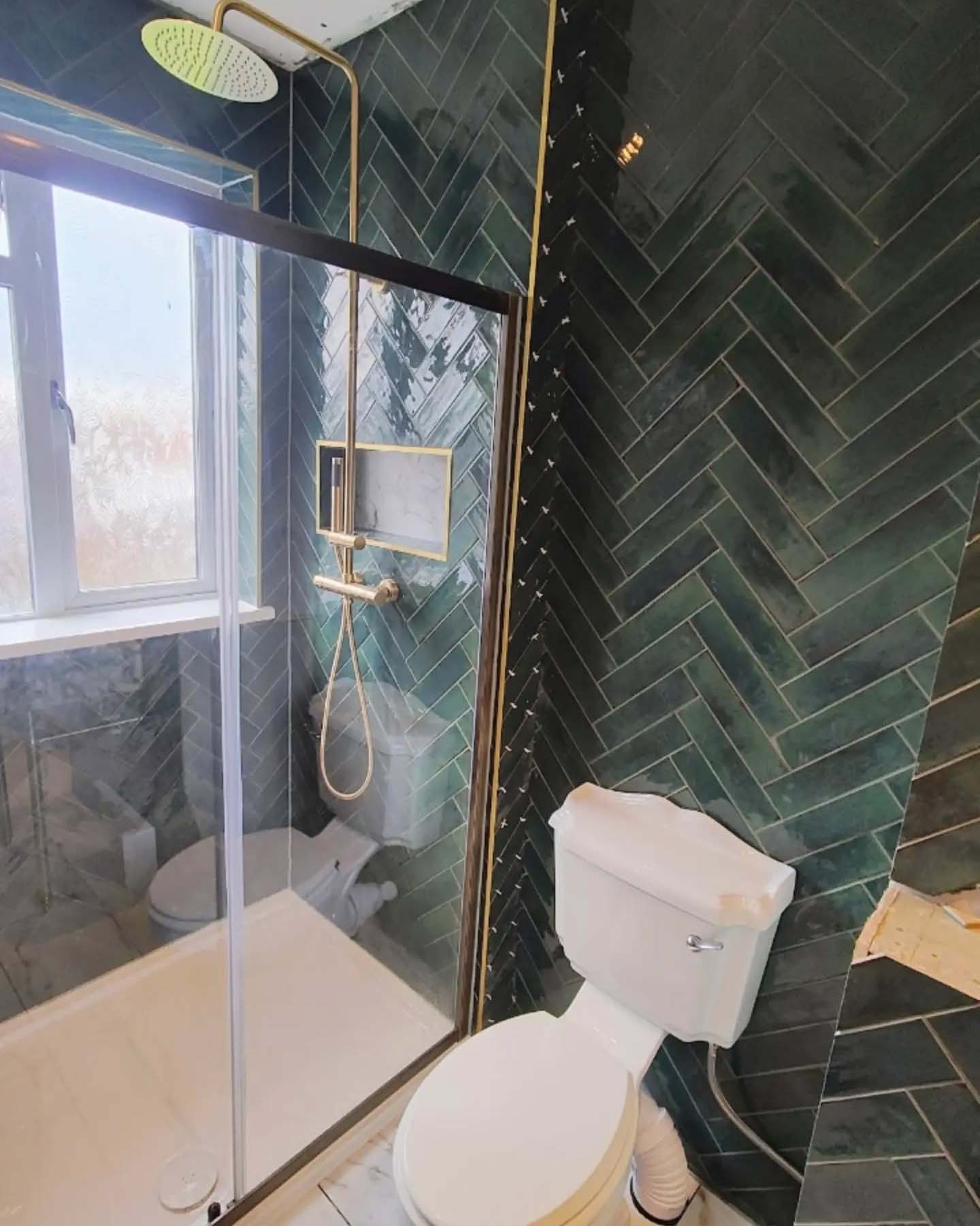 Herringbone style green wall tiles in bathroom
