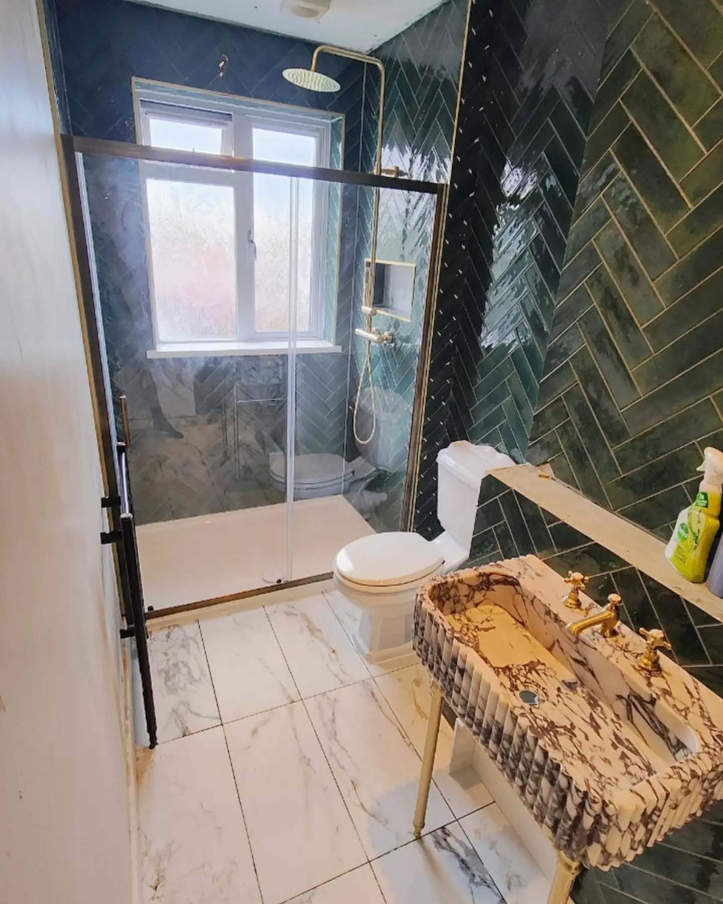 Herringbone style green wall tiles in bathroom with white floor tiles