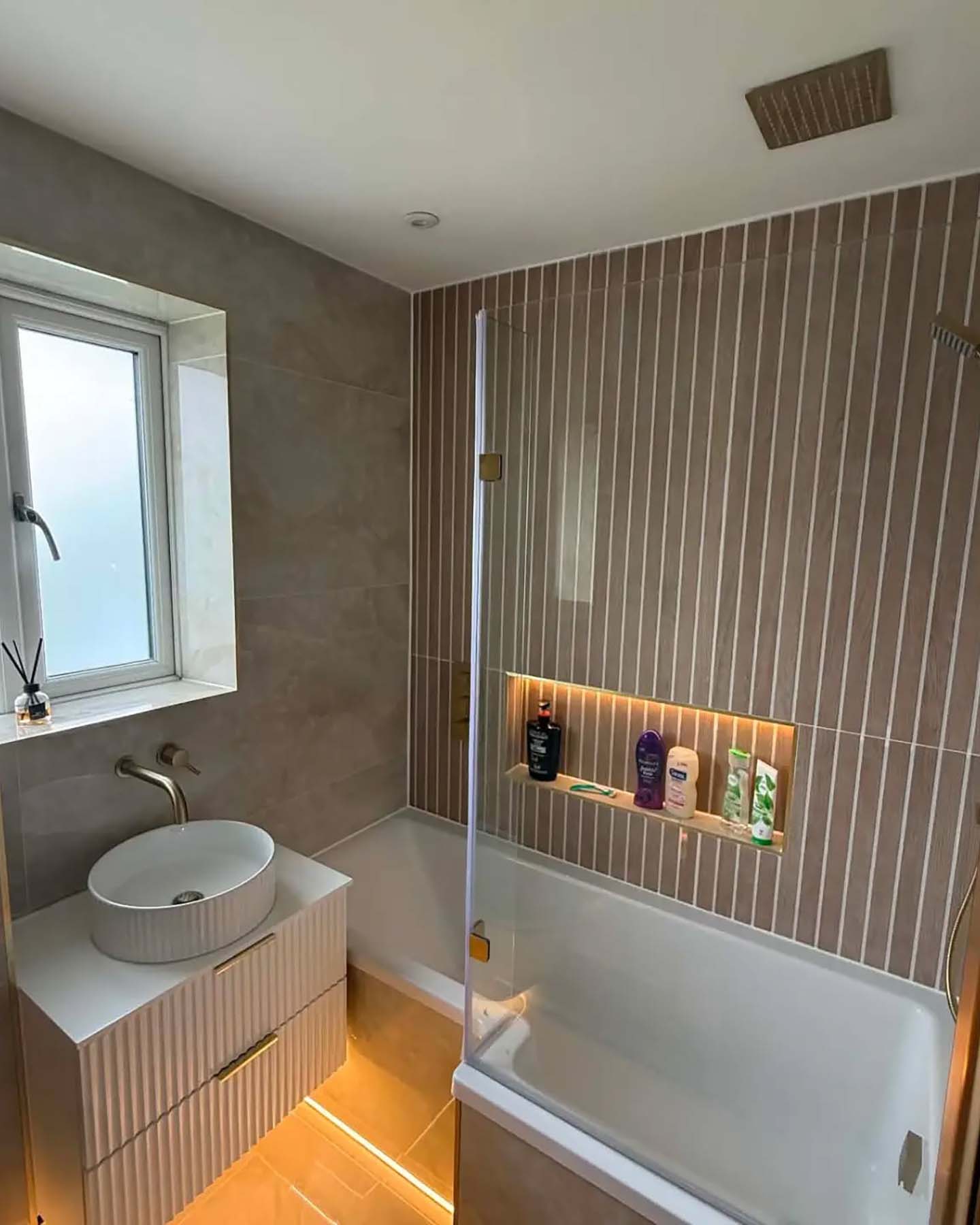 Stone style bathroom with orange lights under bathroom