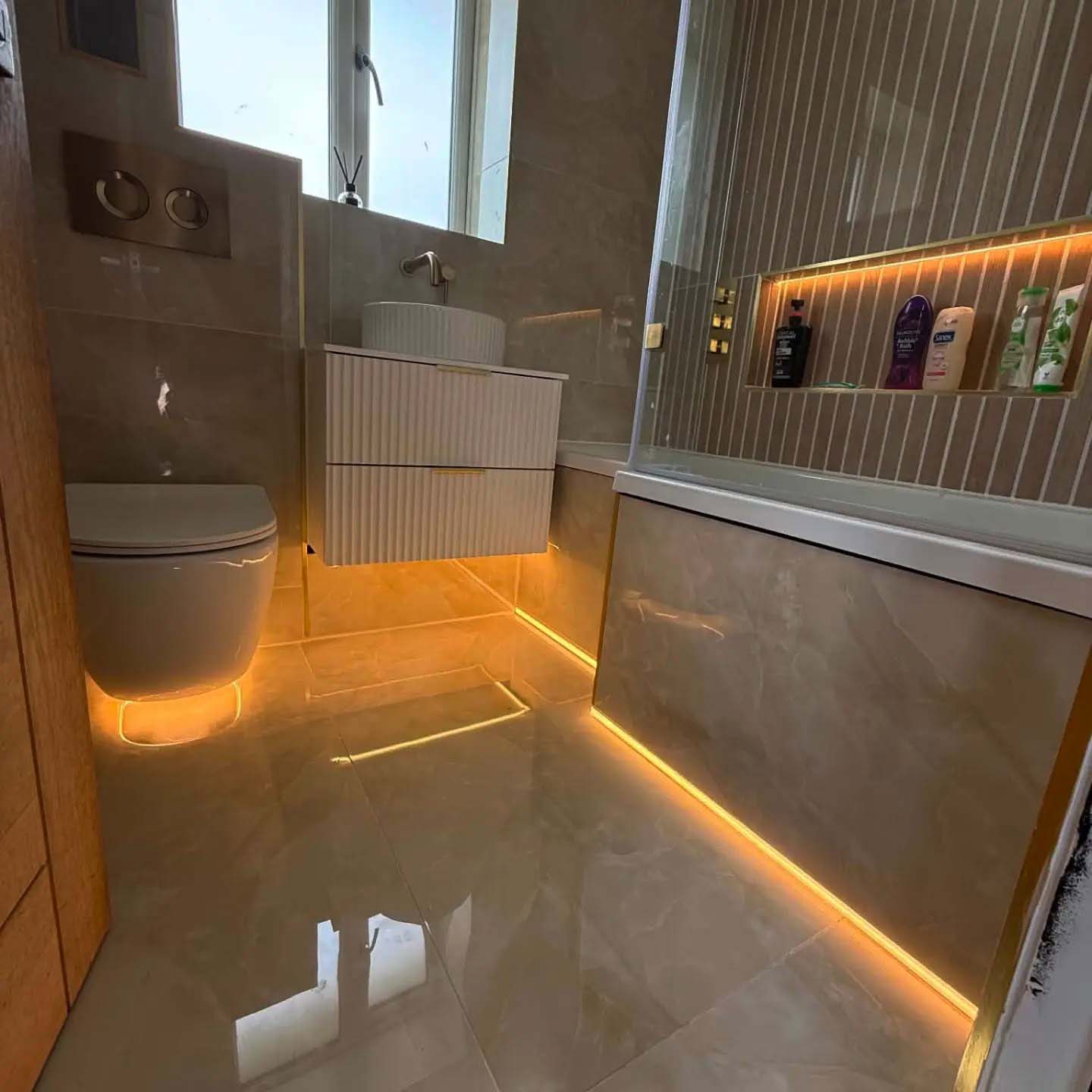 Stone style bathroom with orange lights under bathroom with dark overlay