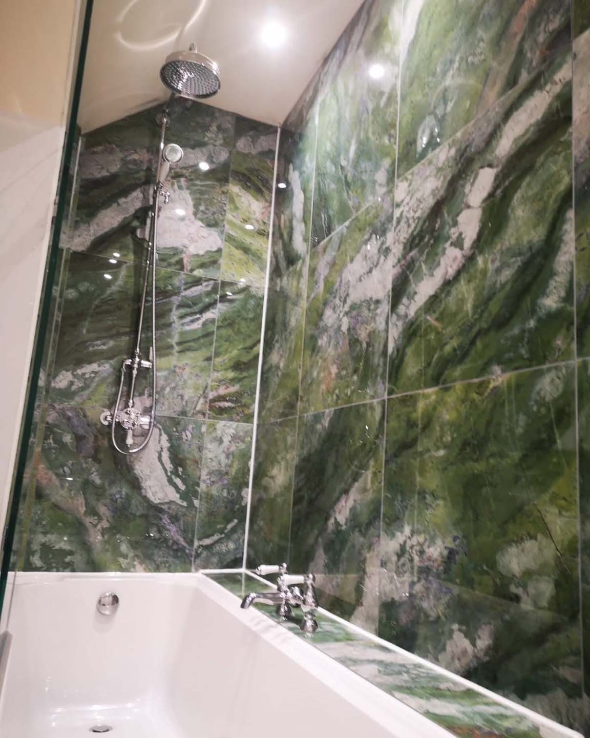 Green stone style tiles in bath enclosure