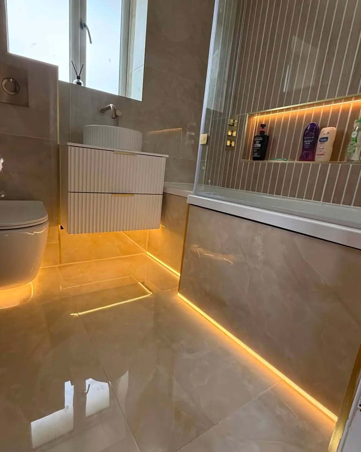 Stone style bathroom with orange lights under bathroom with dark overlay